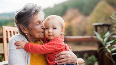 Une dame âgée embrasse tendrement un jeune enfant.