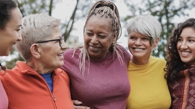 Cinq femmes d’âges et d’origines différentes discutent en souriant.