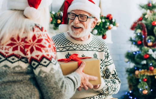 Un grand-père et sa petite-fille qui s'offrent des cadeaux à Noël