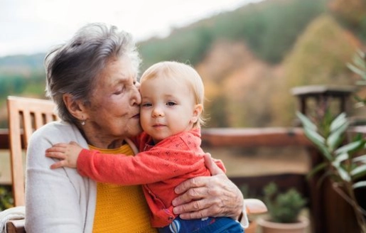 Une dame âgée embrasse tendrement un jeune enfant.