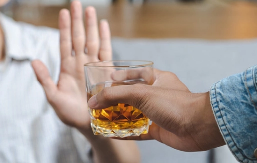 une personne qui refuse de boire un verre d'alcool