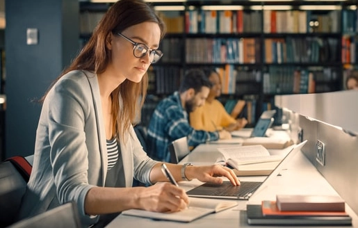 une jeune fille étudie dans une bibliothèque