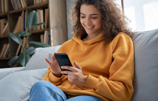 Jeune fille souriante assise dans un canapé