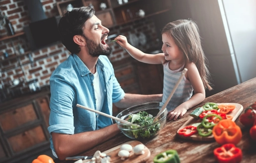 Un père et sa fille cuisinent des légumes