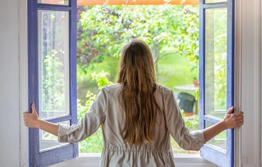 Femme habillée chaudement confortablement assise dans son salon avec un livre.