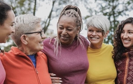 Cinq femmes d’âges et d’origines différentes discutent en souriant.