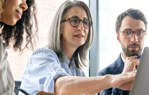 femme devant un ordinateur discute avec ses collègues de bureau