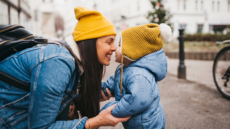 une maman tenant les bras de son enfant
