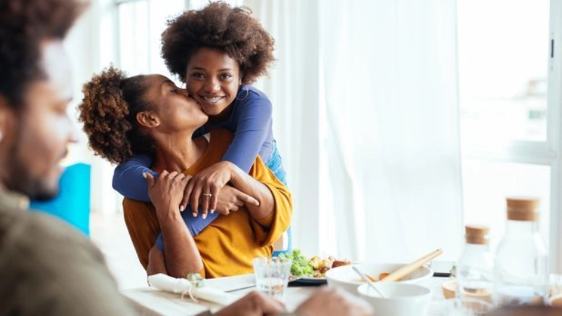 une maman tenant les bras de son enfant