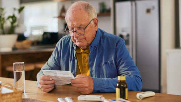 Personne âgée lisant attentivement une notice d'utilisation d'un médicament